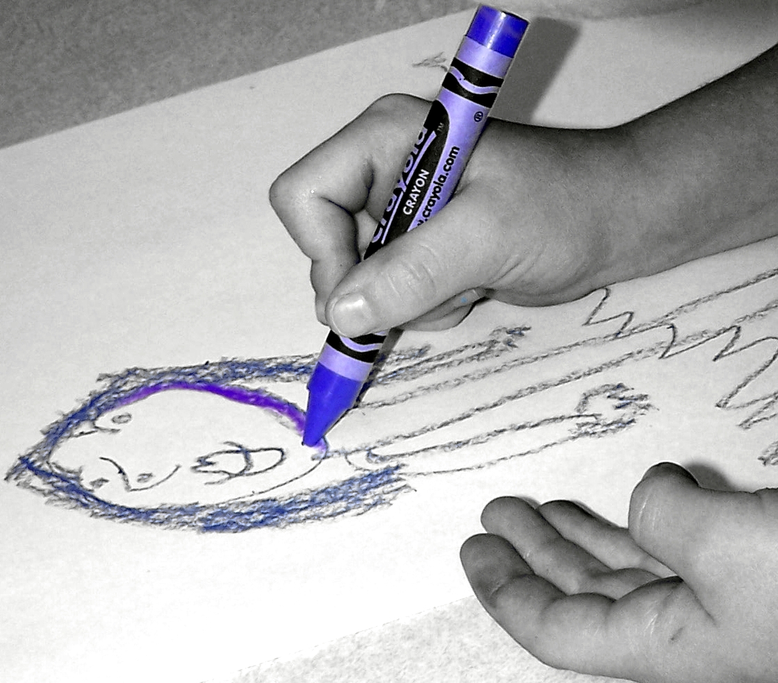 Un enfant en train de dessiner au crayon